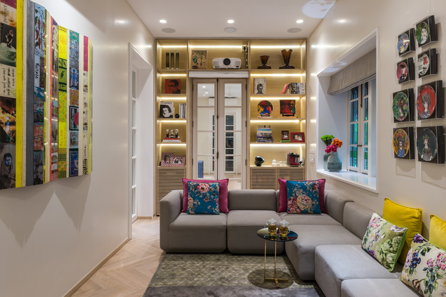 Colourful studio-like family room design, basic colours for furniture and colourful art on the walls