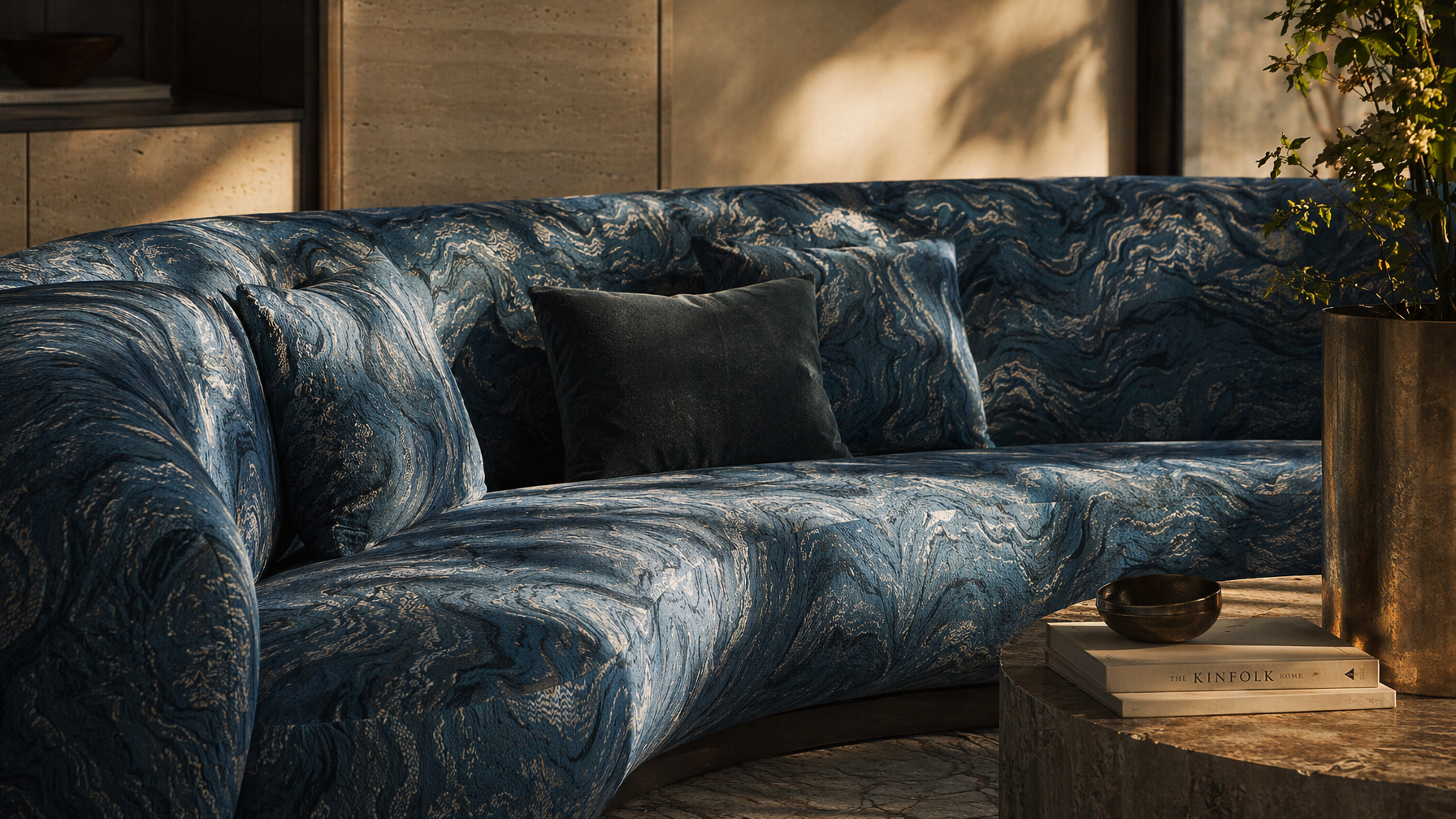 Curved sofa furnishing with blue marbled upholstery, matching patterned cushions, and a plush accent pillow - Beautiful Homes