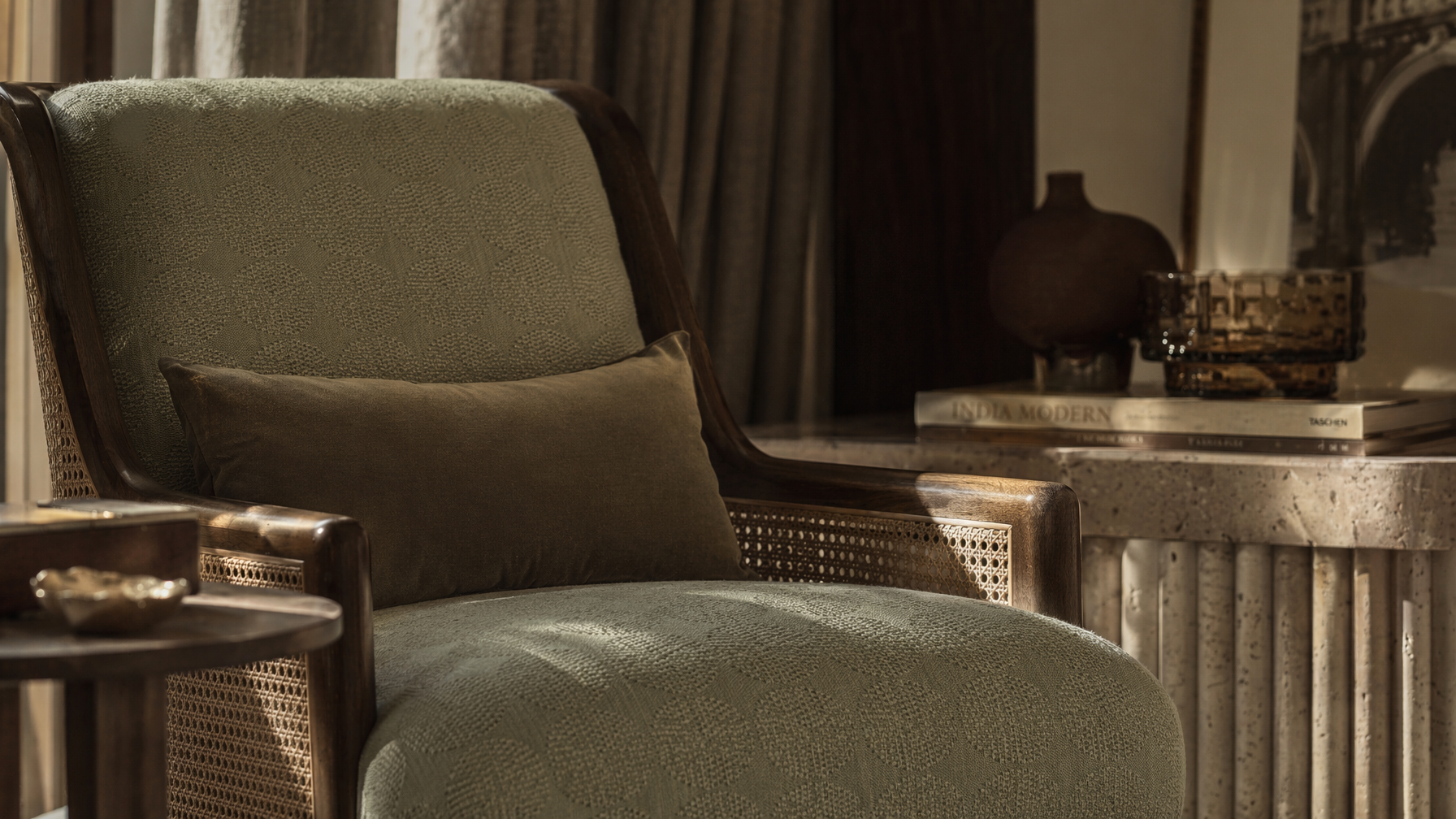 Sofa-style furnishing with a dark wood frame, woven cane side panels, sage textured upholstery, and a contrasting lumbar cushion - Beautiful Homes