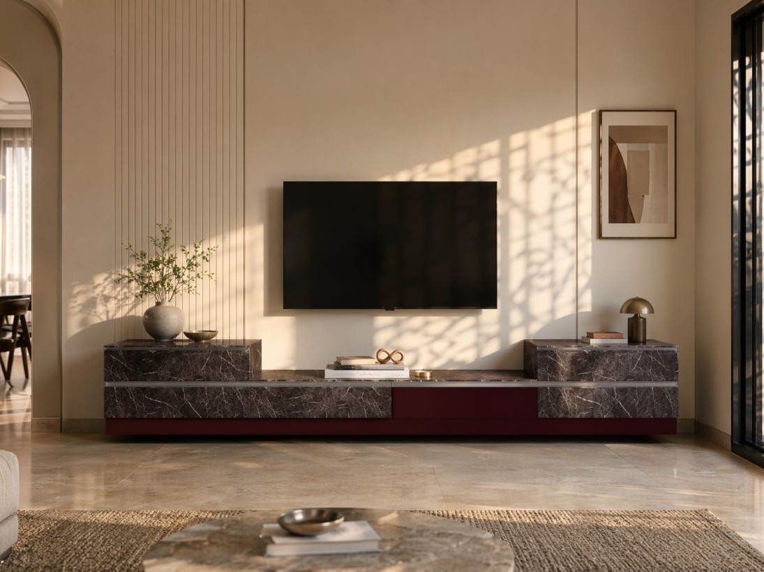 Living room TV unit with dark veined marble finishes, metallic trim, and warm decorative accents against a textured beige wall - Beautiful Homes