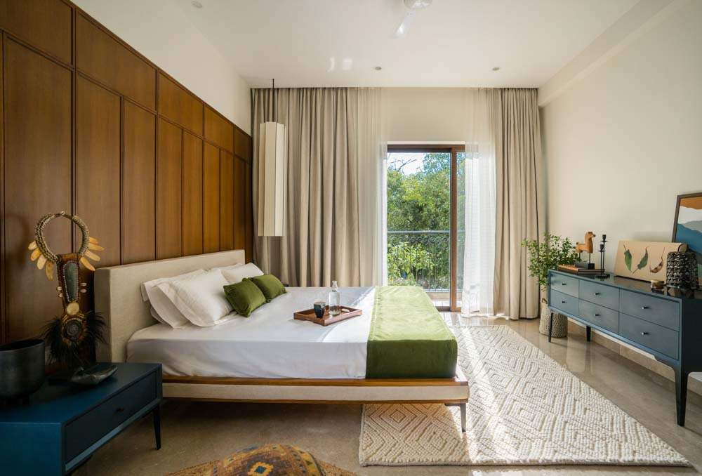 Wood panelling for master bedroom with blue side table & cabinet to balance pop of colours- Beautiful Homes