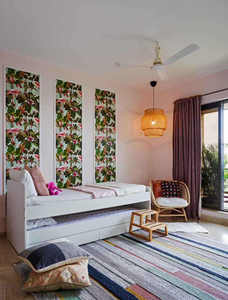 A kids room with a Trundle bed, and colourful artwork on the wall behind - Beautiful Homes