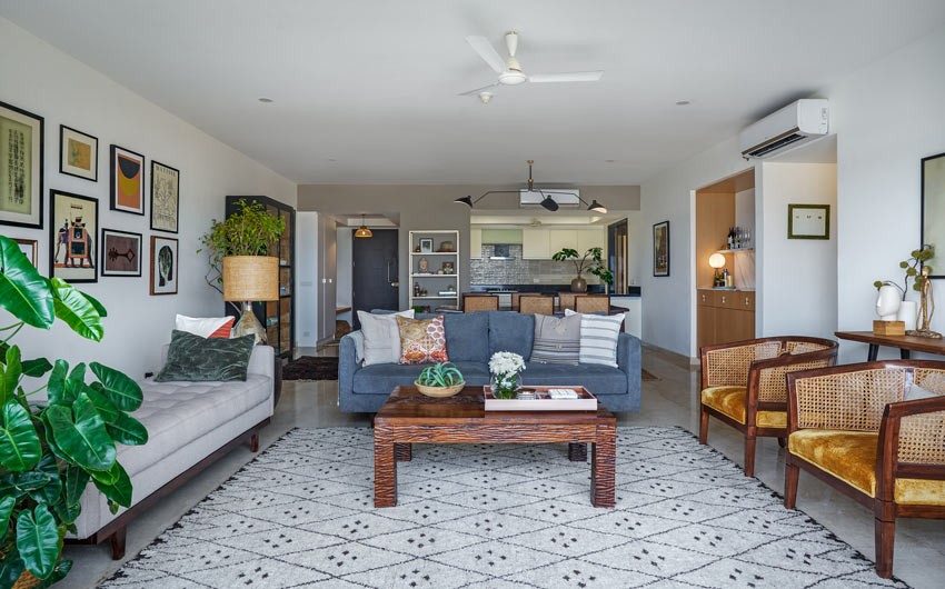 Living room with a blue sofa, two rattan chairs and a grey bench - Beautiful Homes