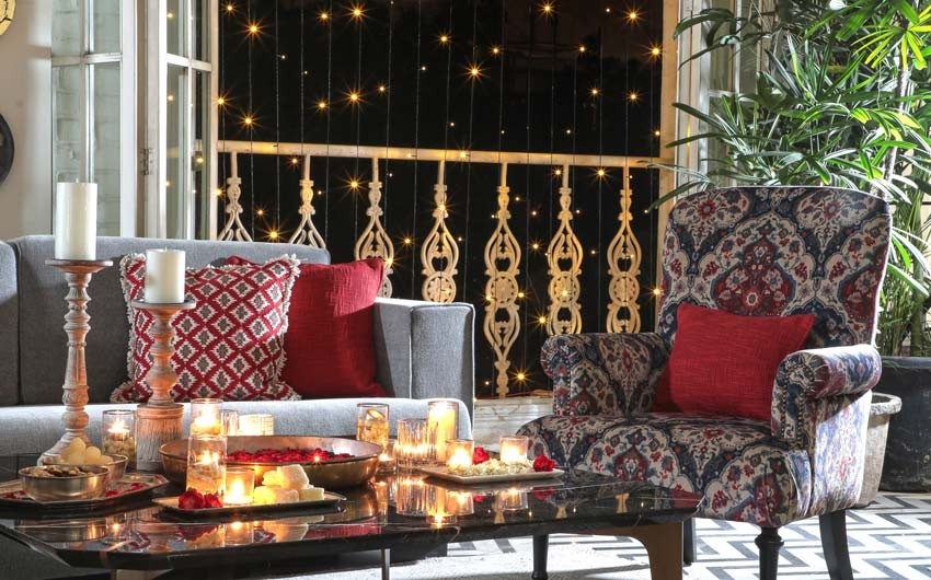 A living room with sofa, armchair and a balcony decorated with lights - Beautiful Homes